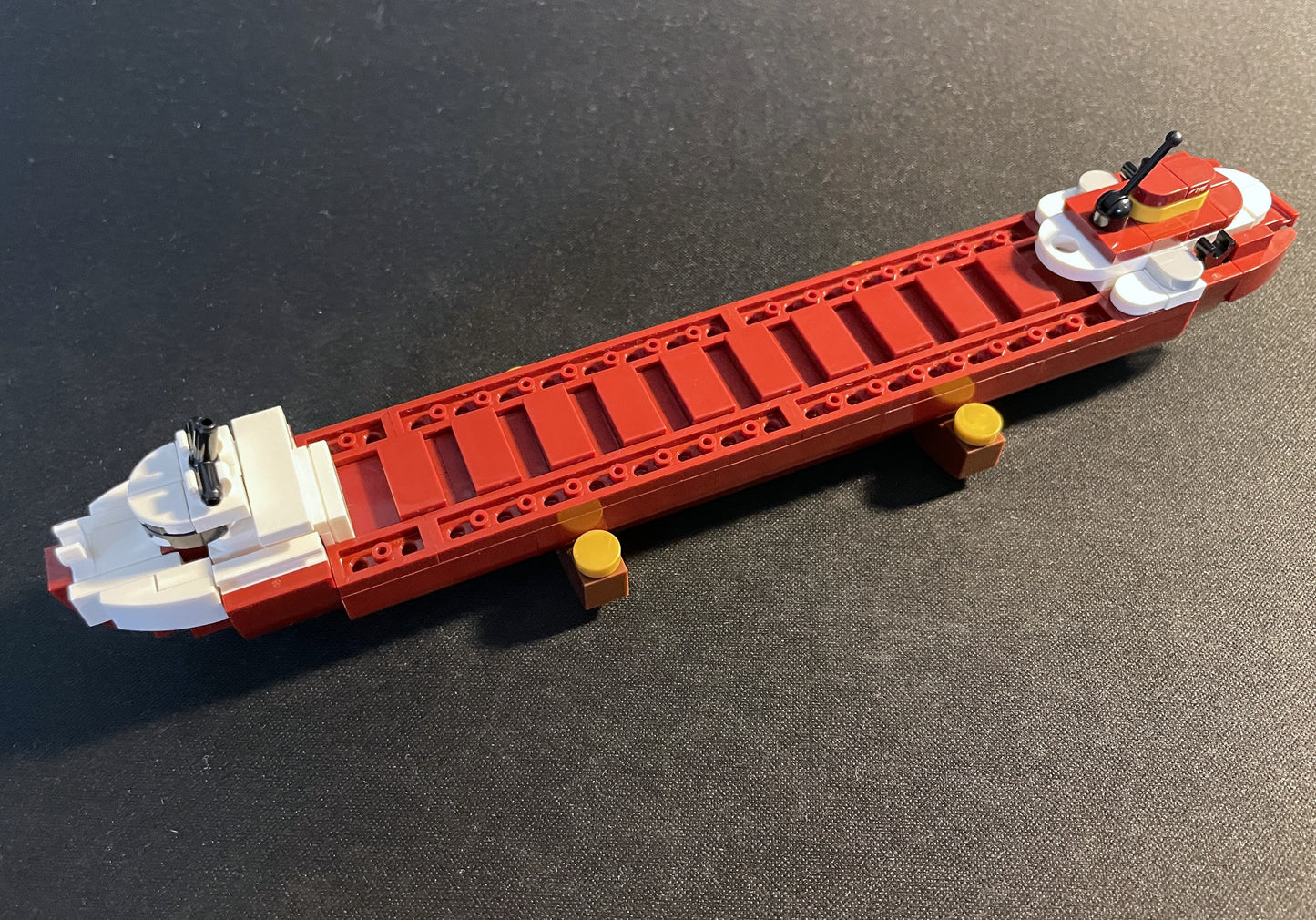 Toy boat made of interlocking bricks on a dark surface.