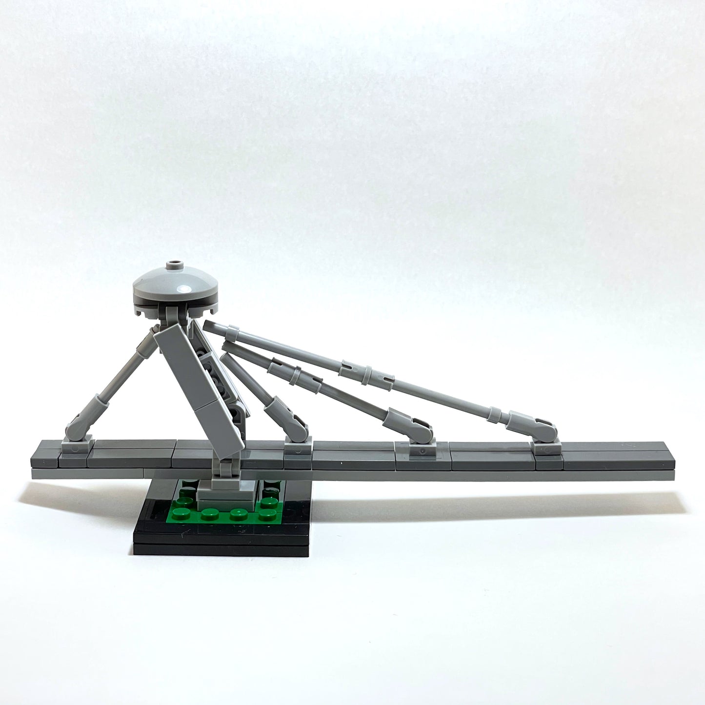 Gray mechanical model with a tripod-like structure on a white background