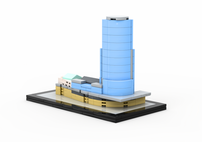 Model of a modern building with a blue cylindrical tower on a white background