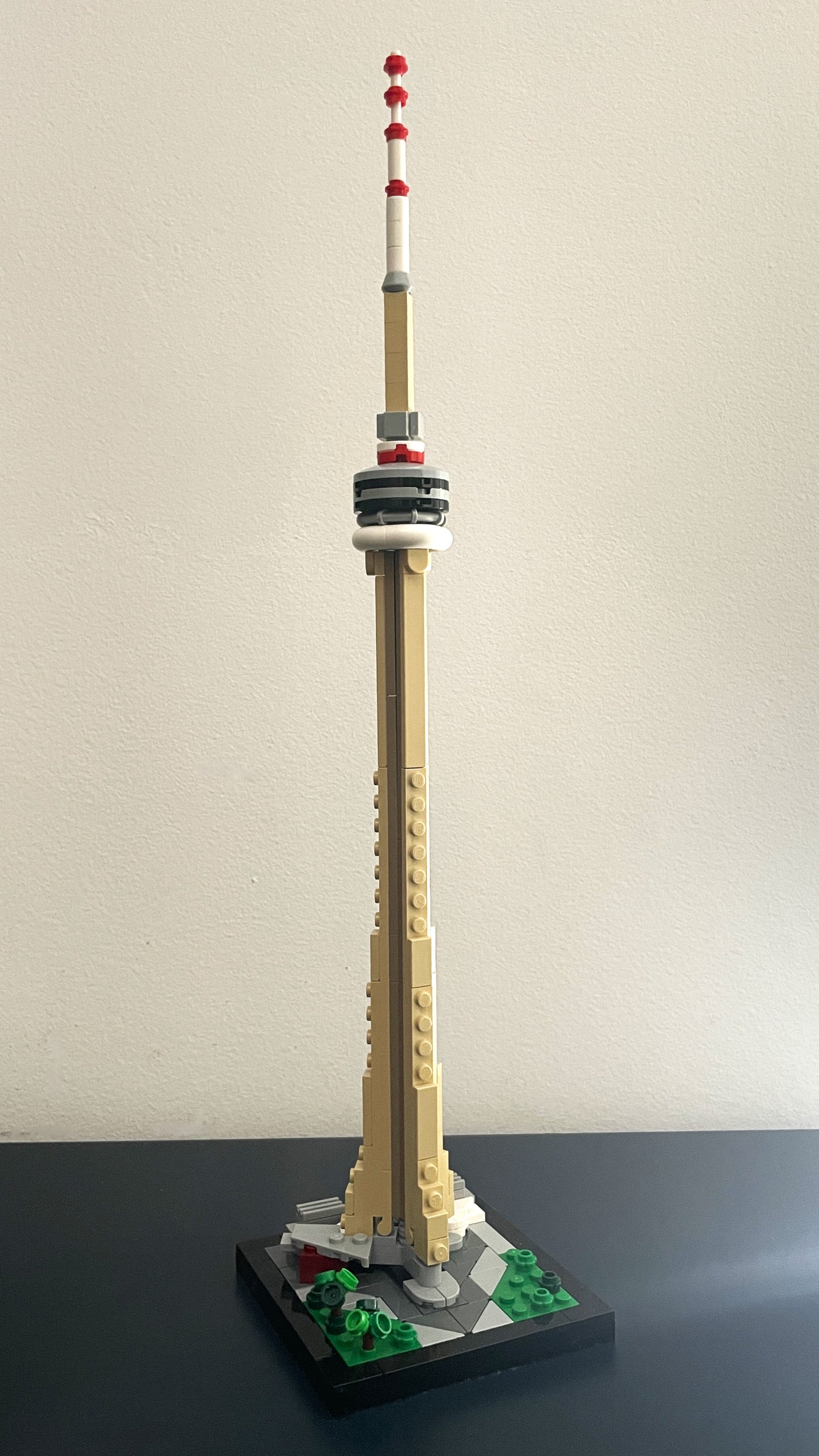 Model of a tower resembling the CN Tower made from building blocks on a plain background.