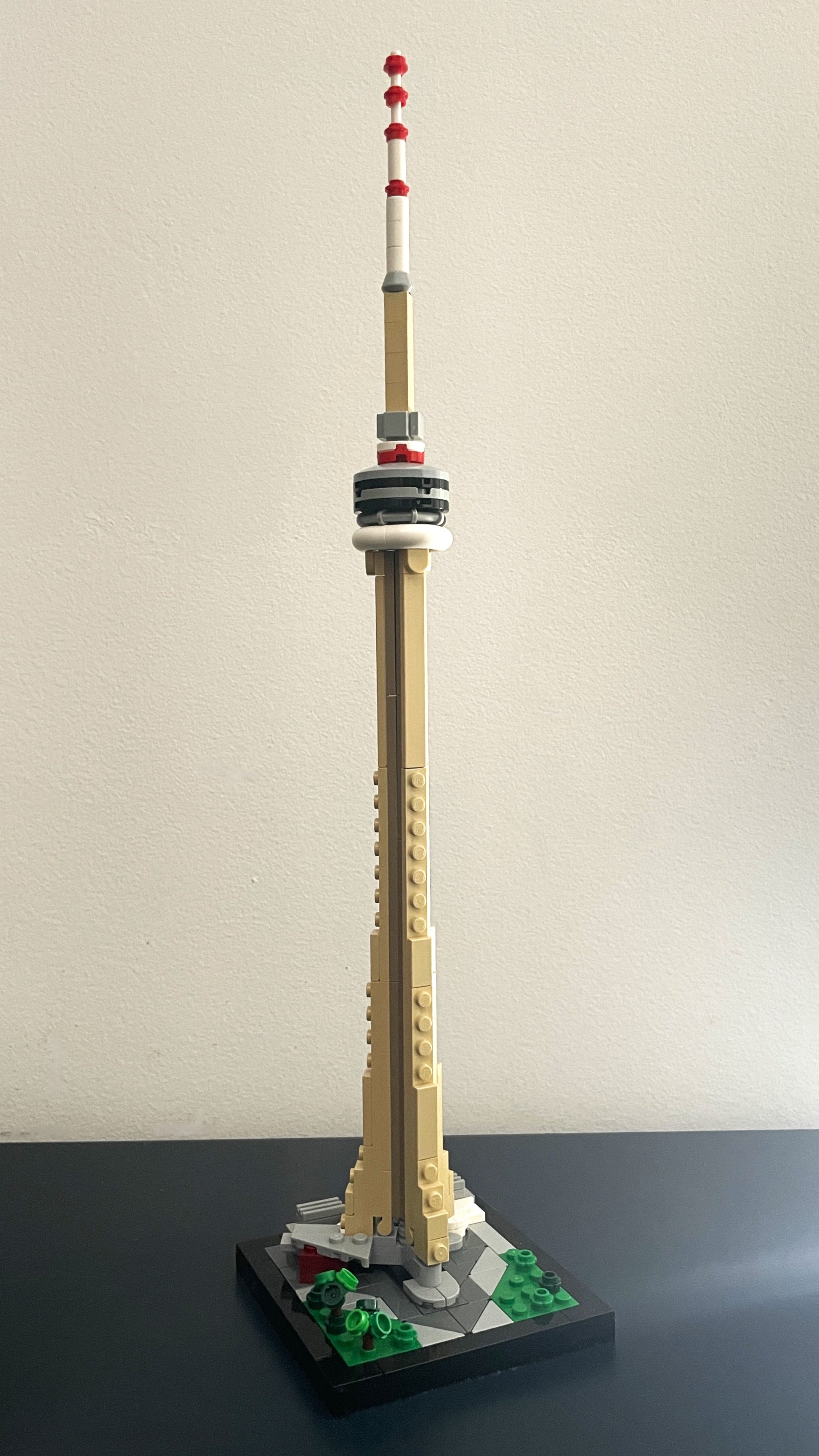 Model of a tower resembling the CN Tower made from building blocks on a plain background.