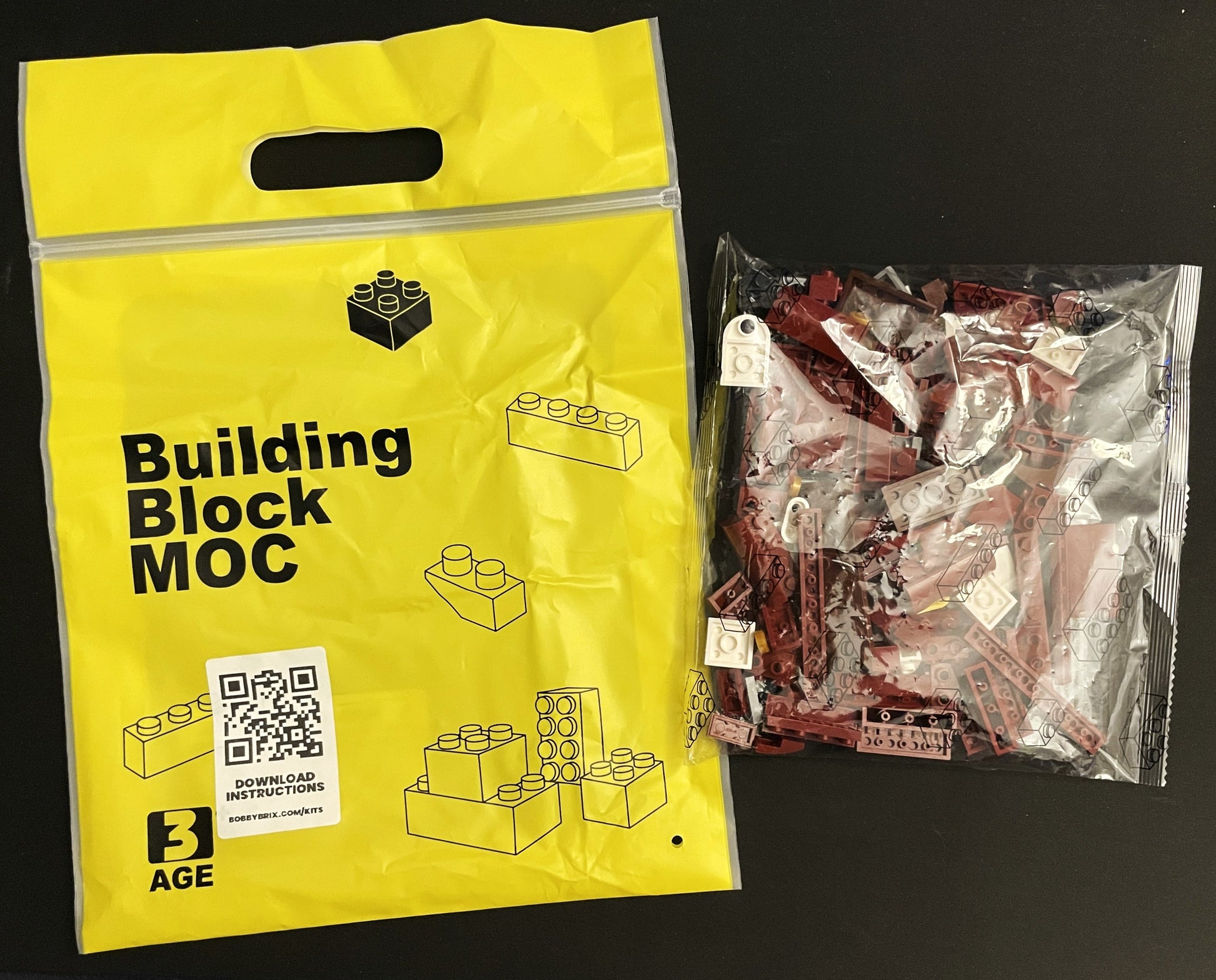 Yellow 'Building Block MOC' bag with a clear plastic bag containing building blocks on a black background.
