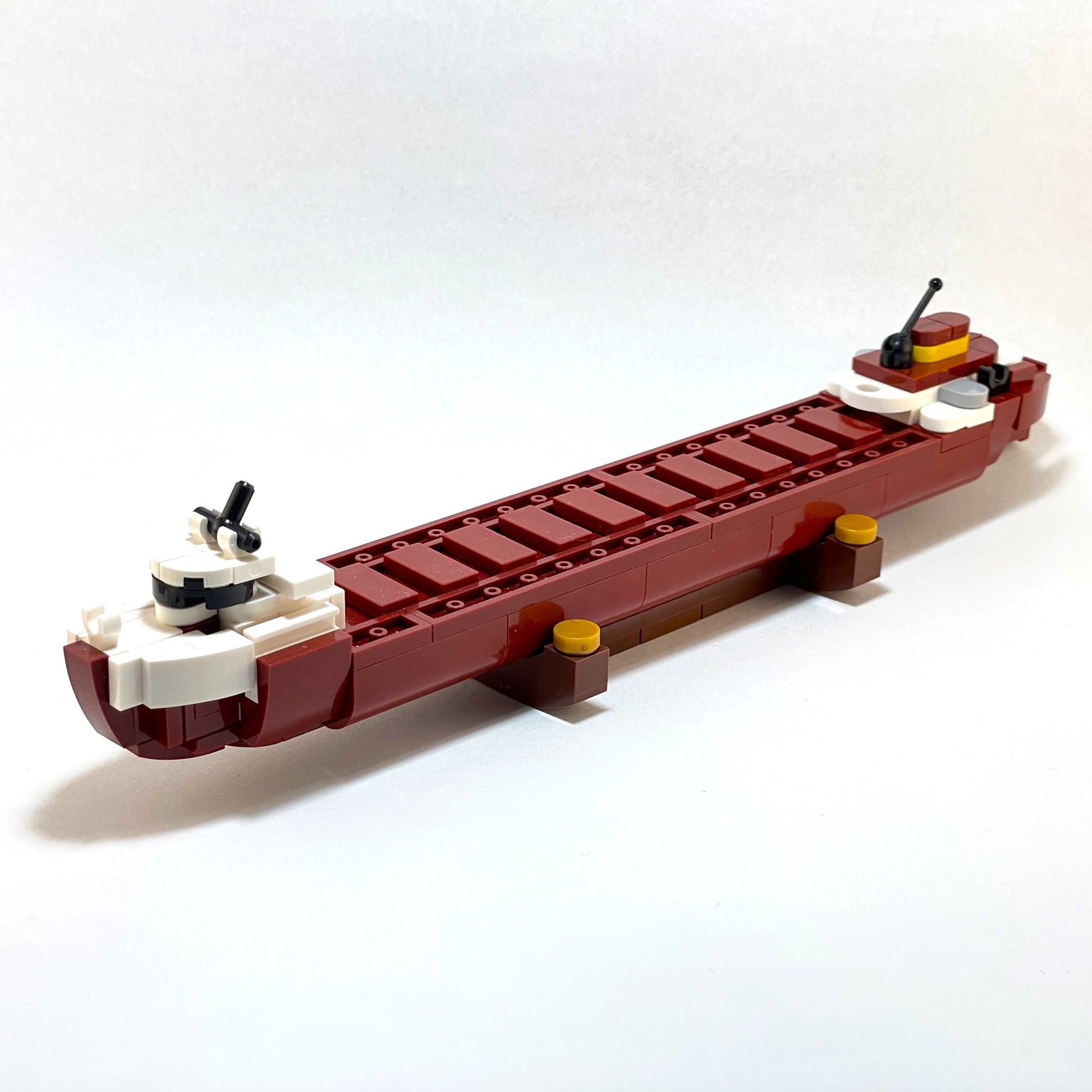 Model of a boat made from interlocking bricks on a white background.