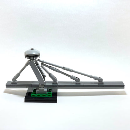Gray mechanical model with a tripod-like structure on a white background